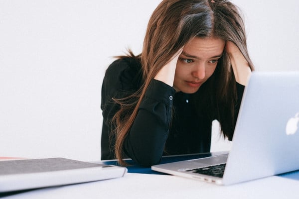 confused young woman looking at a laptop
